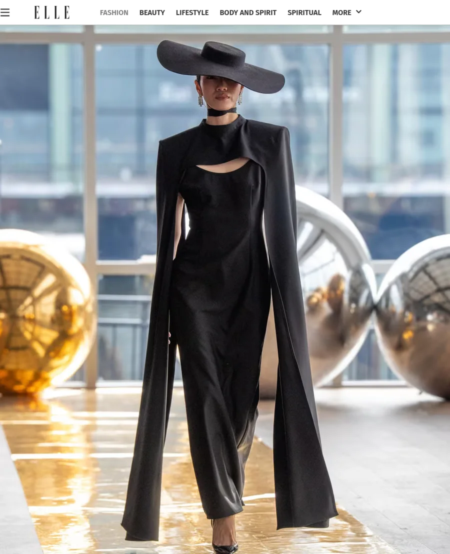 Darin Apinya in a black runway look and wide-brimmed hat, pictured in ELLE coverage